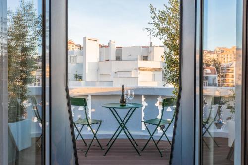 - une vue depuis la fenêtre d'un balcon avec une table et des chaises dans l'établissement Haws Lisboa, à Lisbonne
