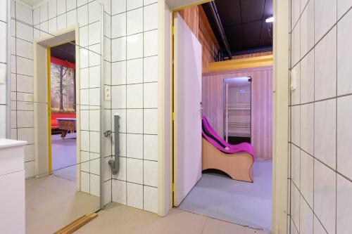 uma casa de banho com uma cadeira rosa num quarto em Au Coeur du Bois em Rendeux