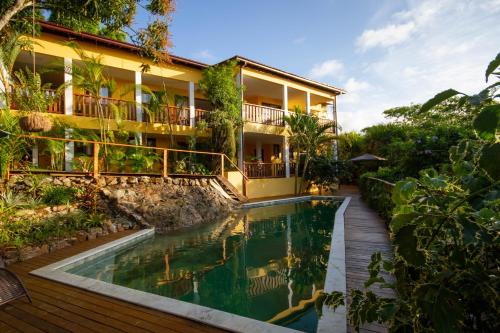 a hotel with a swimming pool in front of a building at Villa Botanic Garden in Itacaré