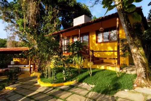 a yellow house with a tree in front of it at Villa Botanic Garden in Itacaré