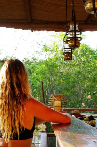 a woman in a black bikini sitting at a counter at Villa Botanic Garden in Itacaré