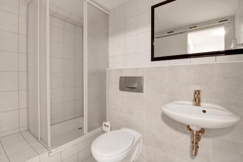 bagno bianco con servizi igienici e lavandino di Stilvoller Bungalow in Selm-Cappenberg a Selm
