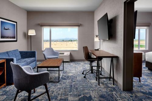 Una habitación de hotel con un sofá, un escritorio y una cama. en Four Points by Sheraton Yuma, en Yuma