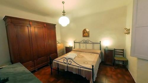 Un dormitorio con una cama y un armario de madera. en La Bandinella, en Albissola Marina