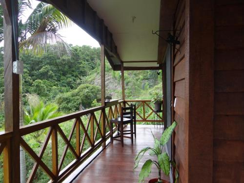 uma varanda de uma casa com vista para a floresta em Cabaña Tribu 