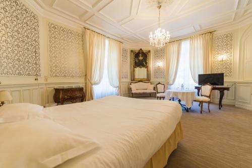 sypialnia z dużym białym łóżkiem i biurkiem w obiekcie Hotel The Originals Château de Perigny w mieście Vouillé