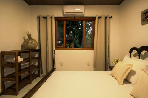 a bedroom with a bed and a window at Villa Botanic Garden in Itacaré