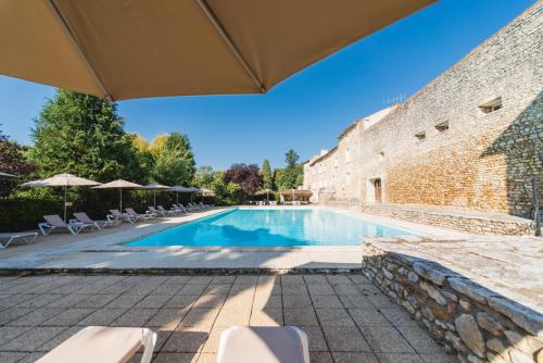 - une piscine avec des chaises et des parasols à côté d'un bâtiment dans l'établissement Hotel The Originals Château de Perigny, à Vouillé