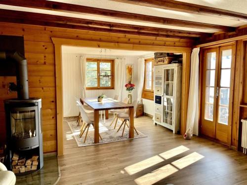 a dining room with a table and a stove at Chalet an sonniger aussichtsreicher Lage in Mund