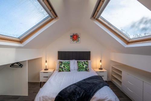 1 dormitorio con 1 cama y 2 ventanas en 2 The Cottage en Upholland