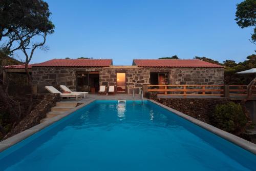 a villa with a swimming pool in front of a house at Pocinhobay in Madalena