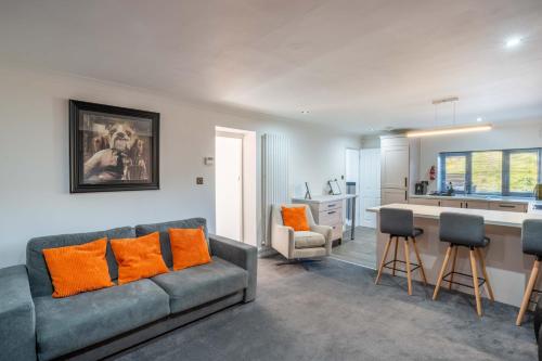 a living room with a couch and a kitchen at 2 The Cottage in Upholland