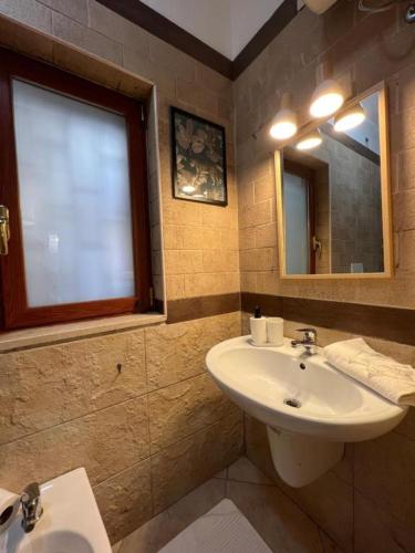 ein Badezimmer mit Waschbecken und Spiegel in der Unterkunft Pardus Domus HOWME in Bari