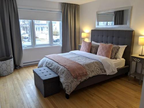 Un dormitorio con una cama grande y una ventana en PRIVATE POOL AND BACKYARD * BBQ * 6 BEDS * 5 MIN. FROM MTL, en Longueuil