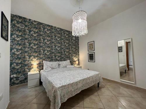 ein Schlafzimmer mit einem Bett und einem Kronleuchter in der Unterkunft Pardus Domus HOWME in Bari