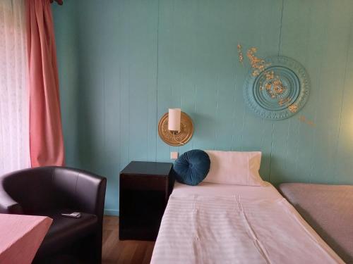 a small room with a bed and a chair at Motel in Teterow