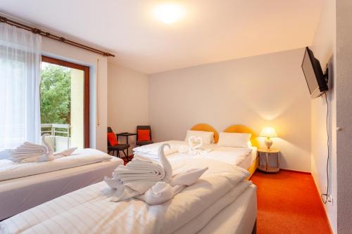 two beds in a room with two swans on them at Hotel-Landgasthof SchachenerHof Lindau Konditorei Biergarten in Lindau