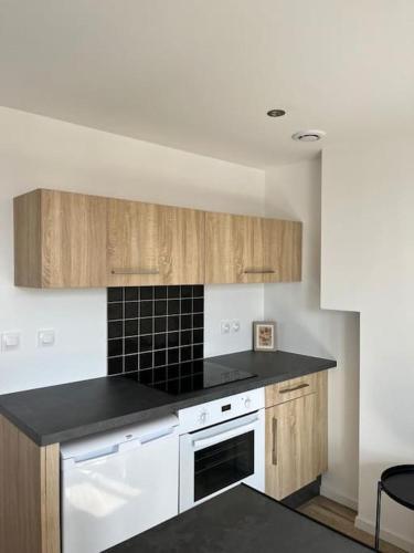 une cuisine avec des armoires en bois et un comptoir noir dans l'établissement Appartement Croix-Rousse, à Lyon