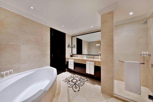 a bathroom with a tub and a sink at Le Meridien Mina Seyahi Beach Resort & Waterpark in Dubai