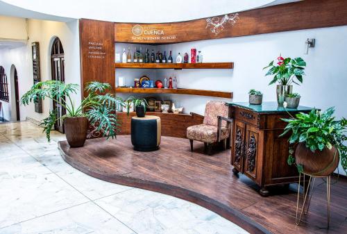 a lobby with a bar with a table and plants at Hotel Cuenca in Cuenca