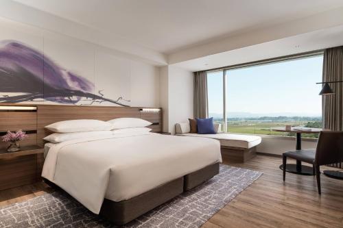 a bedroom with a large bed and a large window at Lake Biwa Marriott Hotel in Moriyama