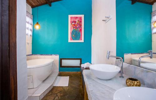 uma casa de banho com 2 lavatórios, uma banheira e um WC. em Pousada Recanto da Villa em Ilhabela
