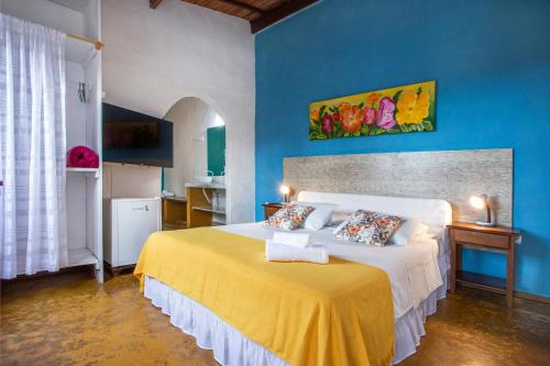 um quarto com uma cama grande num quarto azul em Pousada Recanto da Villa em Ilhabela