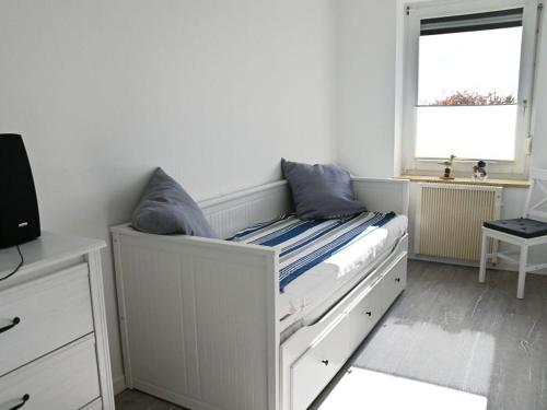 a bedroom with a white bed with blue pillows at Ferienwohnung-Strandpfoetchen in Avendorf auf Fehmarn