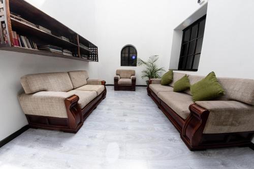 a living room with two couches and a chair at Hotel Cuenca in Cuenca