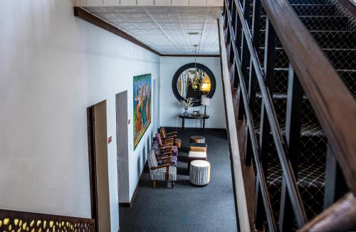 a hallway with a staircase with chairs and a mirror at Hotel Cuenca in Cuenca