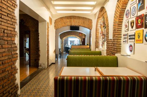 a waiting room with green chairs and a brick wall at Hotel Cuenca in Cuenca