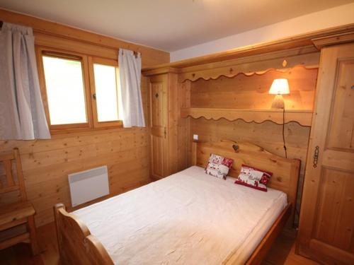Villard-sur-DoronにあるAppartement Villard-sur-Doron, 3 pièces, 6 personnes - FR-1-293-92の木製の部屋にベッド1台が備わるベッドルーム1室があります。
