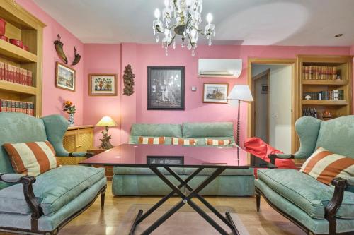Apartamentos Carlos في مدريد: غرفة معيشة مع طاولة وكرسيين