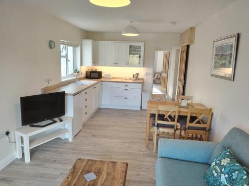 cocina y sala de estar con sofá y mesa en New spacious and sunny annexe with Underfloor heating throughout, en Culmstock