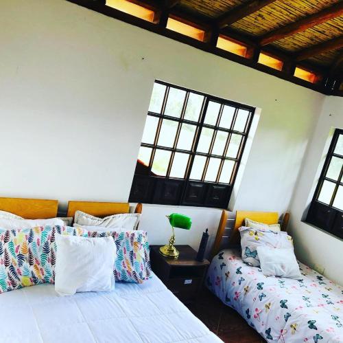 a bedroom with two beds and a window at El Pentagono Verde in Arcabuco