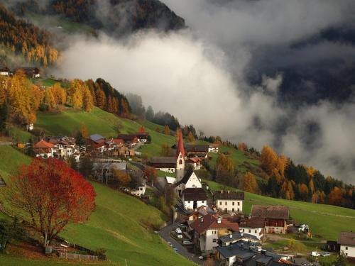 a small village on a hill in the mountains at App Hubertus - Moosstock in Sand in Taufers
