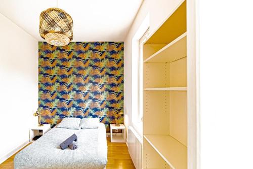 a bedroom with a bed and a wall of shelves at Le petit Raspail-Appartement rénové-Gratte-Ciel in Villeurbanne