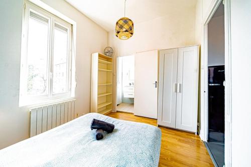 a bedroom with a bed and a window at Le petit Raspail-Appartement rénové-Gratte-Ciel in Villeurbanne