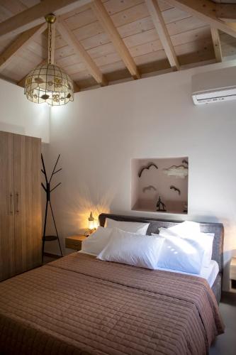 a bedroom with a large bed and a chandelier at Simo's Apartments in Egina