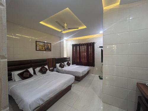 a hotel room with two beds and a ceiling at Jasneet Homestay in Amritsar