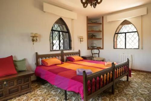 a bedroom with a large bed and two windows at ISLA DEL BURGUILLO in Avila