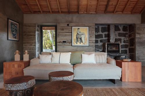uma sala de estar com um sofá e dois repousa-pés em Pocinhobay em Madalena