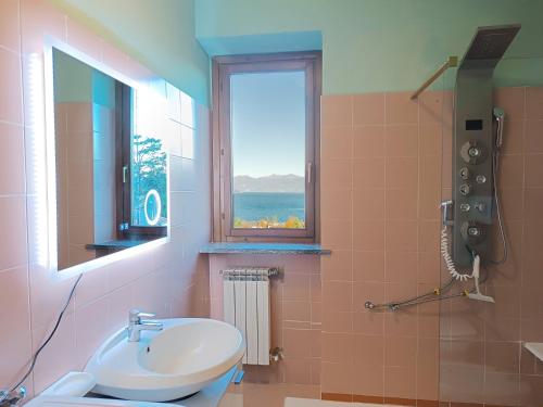 baño con lavabo y ventana en Appartamento Raffaello, en Stresa