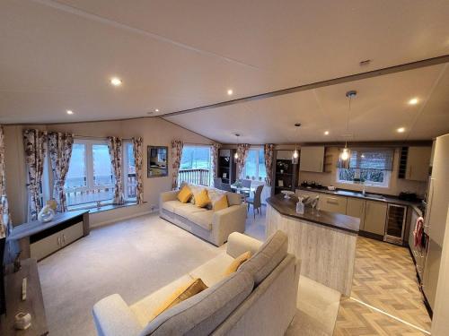 a large living room with two couches and a kitchen at Tulip Lodge with Hot Tub in Malton