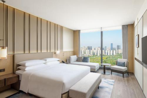 sypialnia z białym łóżkiem i dużym oknem w obiekcie Shaoxing Marriott Hotel Shangyu w mieście Shaoxing