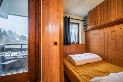 a small room with a bed and a window at Appartement Morillon 4pers in Morillon