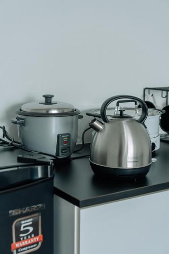 two pots and pans sitting on top of a stove at SUMMER SUITES APARTMENT CASETTA HOMESTAY 1 at Kota Samaraham Kuching in Kota Samarahan