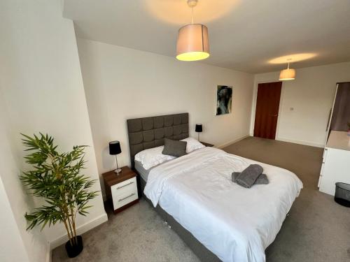 a bedroom with a bed and a potted plant at Liverpool Waterfront Apartment in Liverpool
