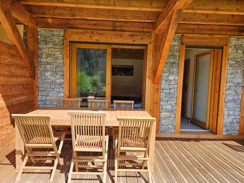 une table et des chaises en bois sur une terrasse dans l'établissement Demi-Chalet Vadel La Panthiaz 15 Pers 5 chambres, à La Chapelle-dʼAbondance