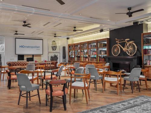 a library with tables and chairs and a fireplace at H10 Metropolitan 4* Sup in Barcelona